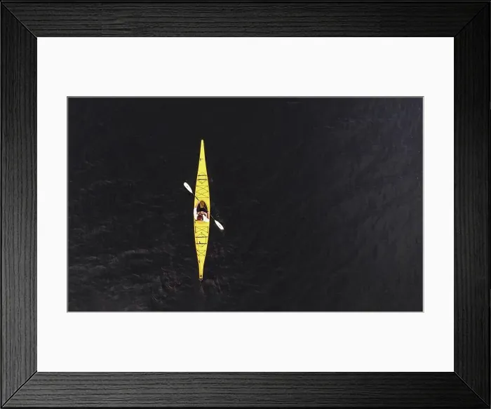 Framed Print : Aerial view of woman paddling yellow kayak on dark lake water Framed Print : Aerial view of woman paddling yellow kayak on dark lake water