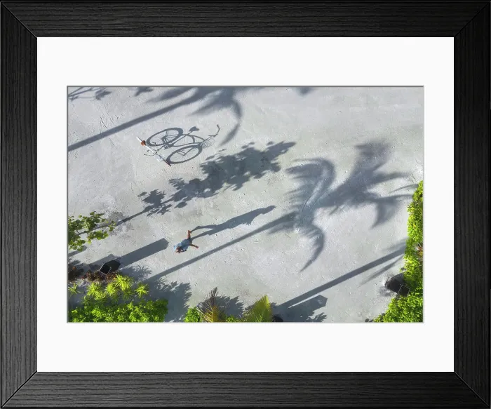 Framed Print : Aerial view of man with bicycle under palm trees Framed Print : Aerial view of man with bicycle under palm trees