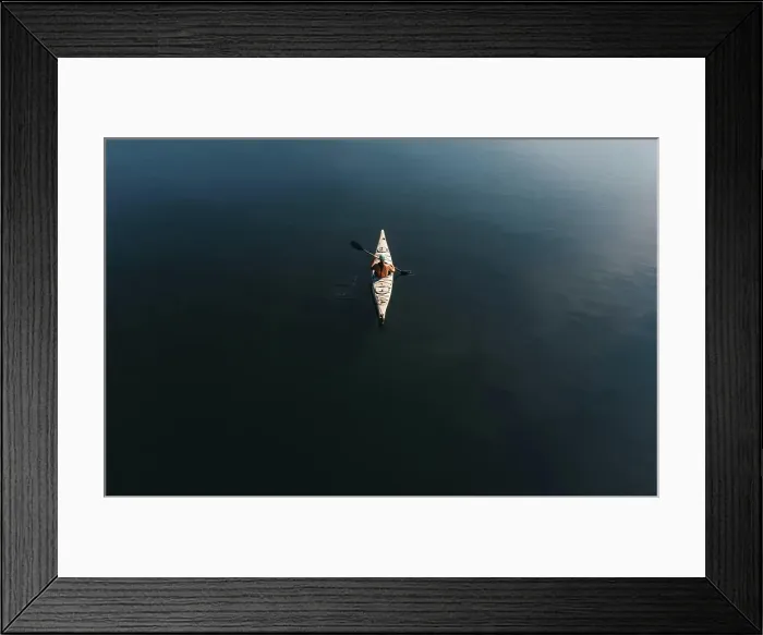 Framed Print : Overhead aerial view of woman paddling kayak on dark blue water Framed Print : Overhead aerial view of woman paddling kayak on dark blue water