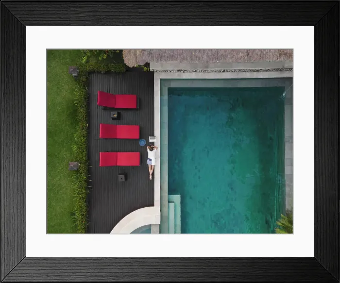Framed Print : Aerial view young woman with laptop near pool