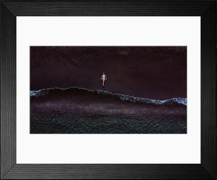 Framed Print : Aerial view of a woman lying on a sandy beach near the water
