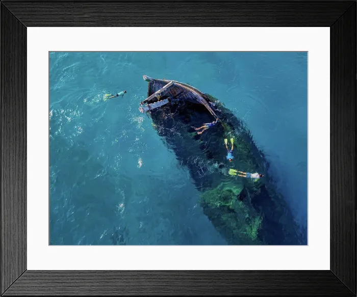 Framed Print : Aerial view of four men snorkeling around sunken shipwreck Framed Print : Aerial view of four men snorkeling around sunken shipwreck