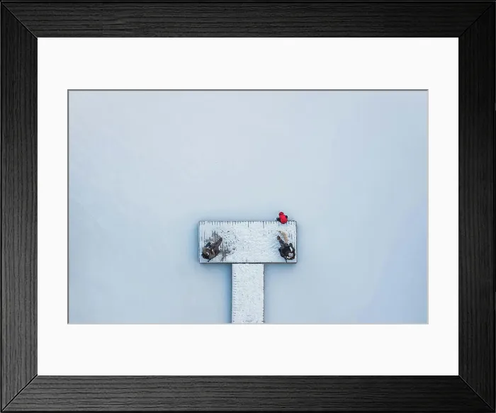 Framed Print : Aerial view of people sitting on snowy dock on frozen lake in winter