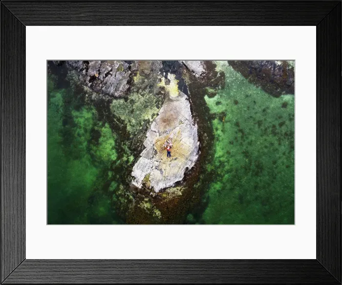 Framed Print : Aerial view of family lying on rock surrounded by clear green water Framed Print : Aerial view of family lying on rock surrounded by clear green water