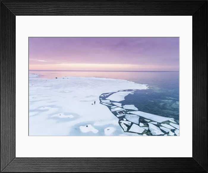 Framed Print : Aerial view of a man walking his dog on the frozen sea in Muraste at sunset, Estonia Framed Print : Aerial view of a man walking his dog on the frozen sea in Muraste at sunset, Estonia