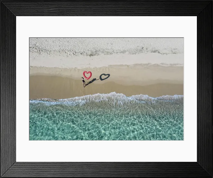 Framed Print : Person standing on the beach drawing a heart in the sand with aerial ocean view Framed Print : Person standing on the beach drawing a heart in the sand with aerial ocean view