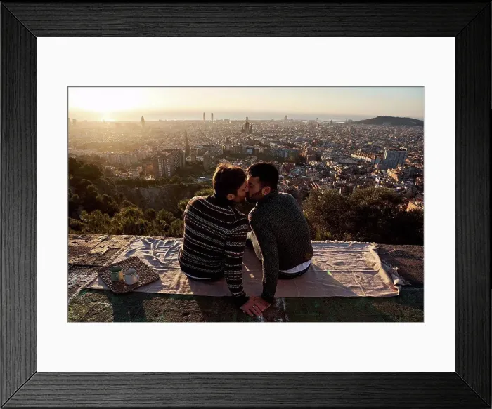 Framed Print : Gay men kissing while sitting on observation point against cityscape, Bunkers del Carmel, Barcelona, Spain