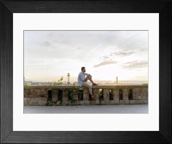 Framed Print : Man sitting on a wall on lookout above the city with view to the port, Barcelona, Spain Framed Print : Man sitting on a wall on lookout above the city with view to the port, Barcelona, Spain