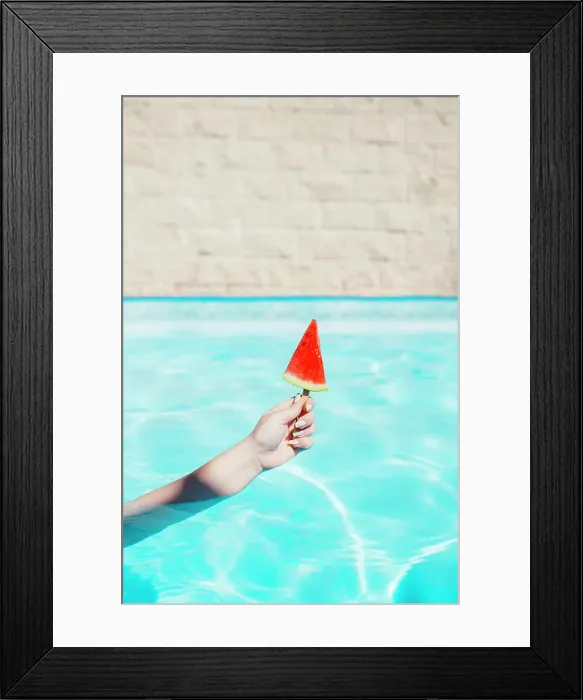 Framed Print : Hand of woman holding watermelon slice with popsicle stick in swimming pool