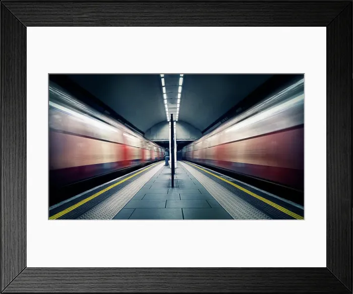 Framed Print : Two trains in motion and a seated commuter at London Tube Station