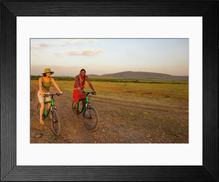 Framed Print : Tourist with guide on mountain bike safari in the Maasai Mara National Reserve, Kenya, Africa; Maasai Mara, Kenya Framed Print : Tourist with guide on mountain bike safari in the Maasai Mara National Reserve, Kenya, Africa; Maasai Mara, Kenya