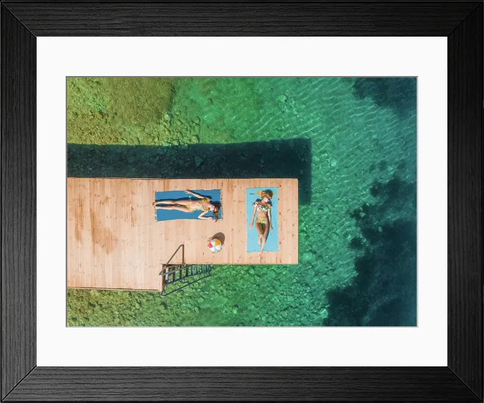 Framed Print : Aerial view of two attractive women sunbathing on wooden pontoon in Panagopoula, Greece Framed Print : Aerial view of two attractive women sunbathing on wooden pontoon in Panagopoula, Greece