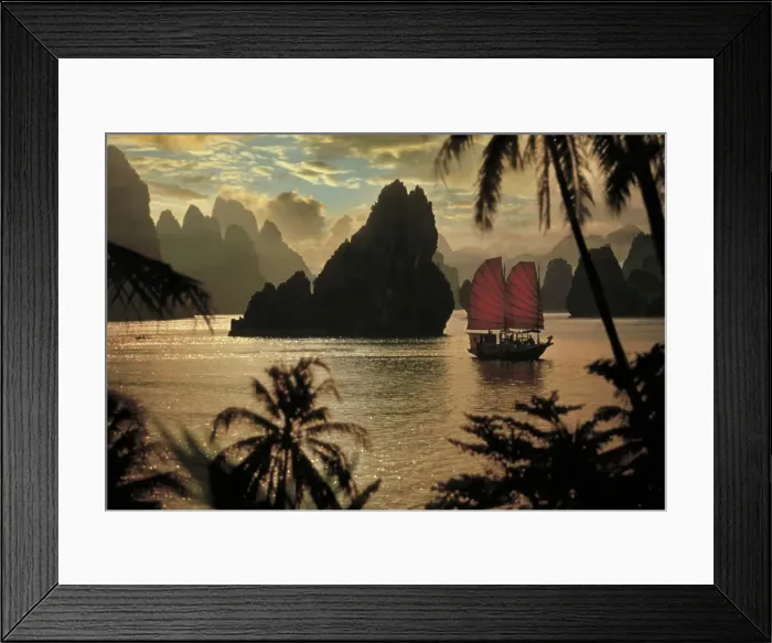 Framed Print : A small ship with red sales navigates through Halong Bay in Vietnam