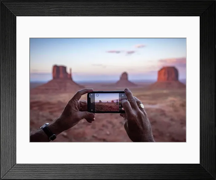 Framed Print : An adult male tourist takes a phone photo at Monument Valley, Arizona