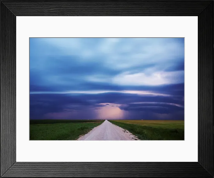 Framed Print : USA, Oklahoma, Dirt road disappears in distance below mesocyclone