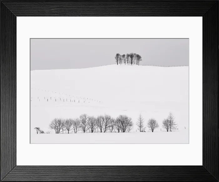 Framed Print : Snow-covered winter landscape with small copse on distant hill Framed Print : Snow-covered winter landscape with small copse on distant hill