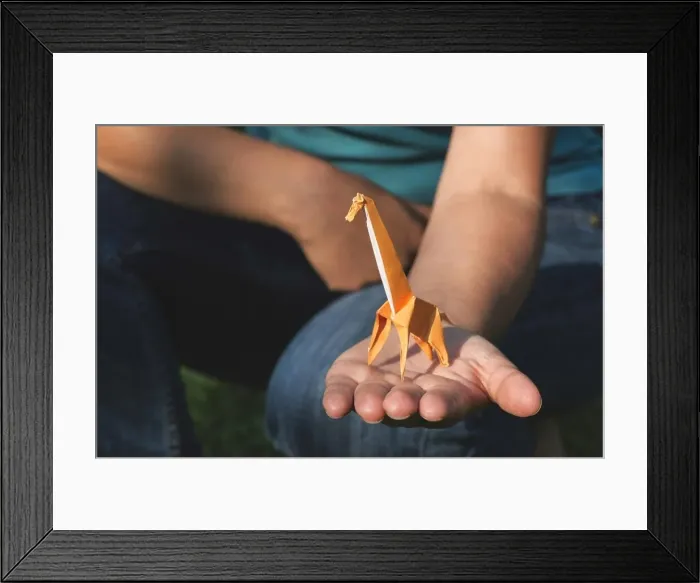Framed Print : Origami orange color giraffe on hand