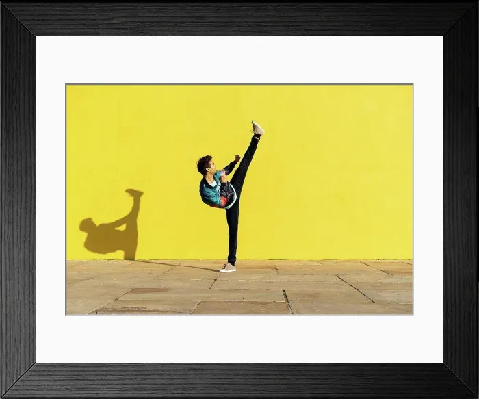 Framed Print : Acrobat doing movement training in front of a yellow wall Framed Print : Acrobat doing movement training in front of a yellow wall