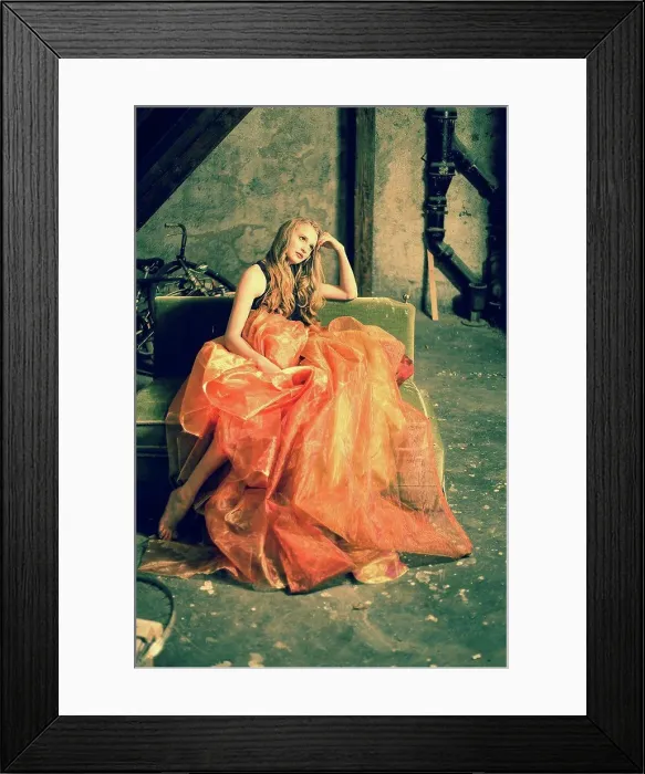 Framed Print : Portrait of young woman sitting at attic wearing orange skirt