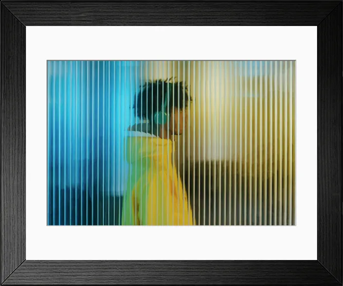 Framed Print : Young man in wireless headphones behind futuristic wall Framed Print : Young man in wireless headphones behind futuristic wall