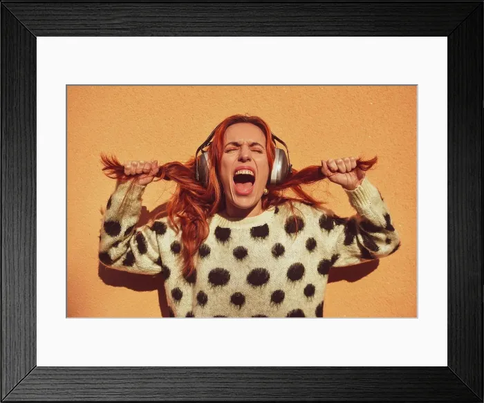 Framed Print : White Caucasian woman with red hair wearing helmets to protect herself from noise pulls her pigtails while screaming Framed Print : White Caucasian woman with red hair wearing helmets to protect herself from noise pulls her pigtails while screaming