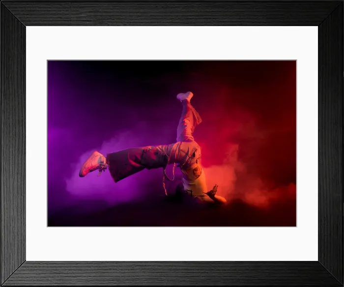 Framed Print : Modern female performing break dance on floor in purple and red smoke on black background Framed Print : Modern female performing break dance on floor in purple and red smoke on black background