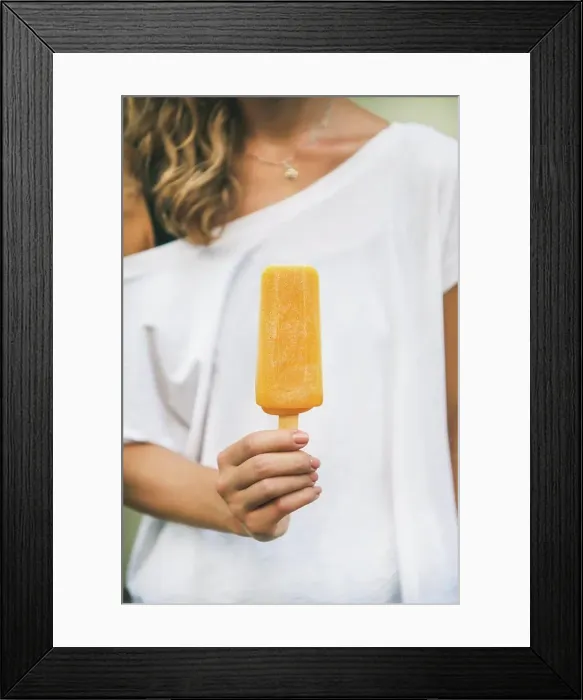 Framed Print : Healthy vegan orange mango citrus ice cream popsicle in hand of young woman