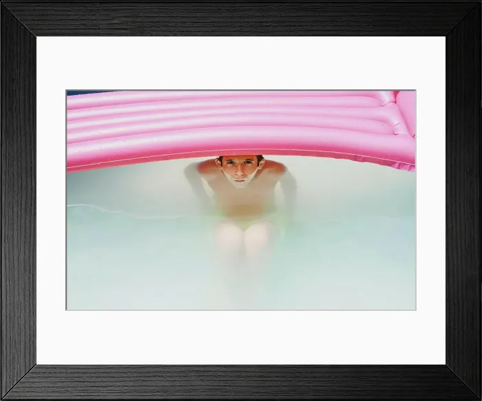 Framed Print : Boy in a pool taking a bath under a pink flat looking at camera Framed Print : Boy in a pool taking a bath under a pink flat looking at camera