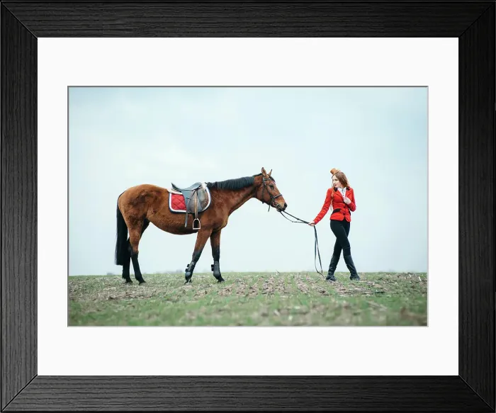 Framed Print : red-haired jockey girl in a red cardigan and black high boots with a horse for a walk Framed Print : red-haired jockey girl in a red cardigan and black high boots with a horse for a walk