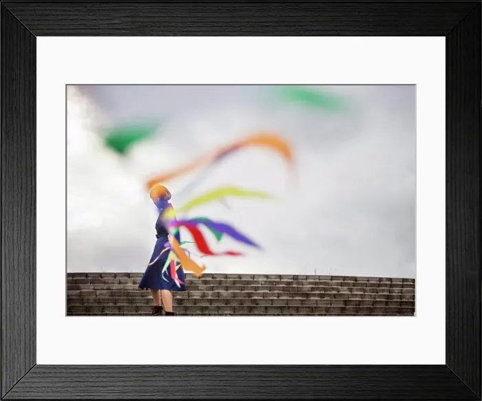 Framed Print : An artist during a performance moving a line of flags or streamers Framed Print : An artist during a performance moving a line of flags or streamers