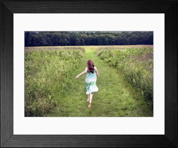 Framed Print : A girl running through a meadow in summer Framed Print : A girl running through a meadow in summer
