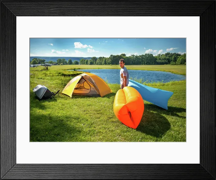 Framed Print : Man setting up Inflatable sofas out in the wild camping in summer Framed Print : Man setting up Inflatable sofas out in the wild camping in summer