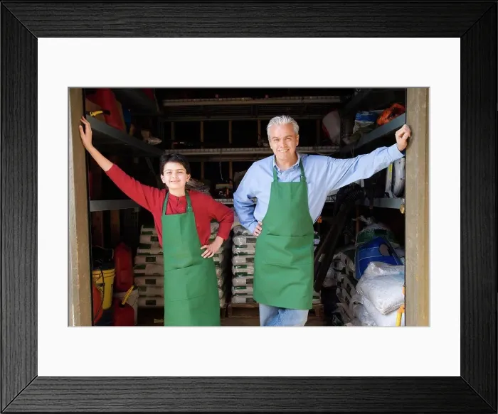 Framed Print : Hispanic father and son working at garden center