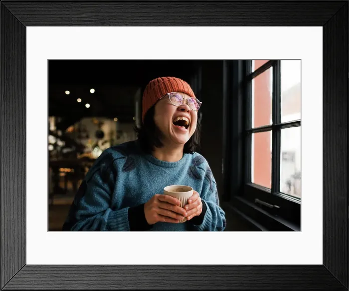 Framed Print : Asian woman laughing having coffee in a cafe Framed Print : Asian woman laughing having coffee in a cafe