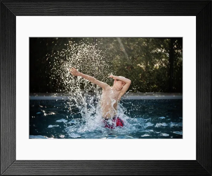 Framed Print : happy 8 years old boy having fun in a swimming pool during summer