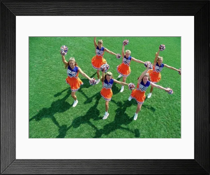 Framed Print : High angle view of a group of cheerleaders cheering in a field