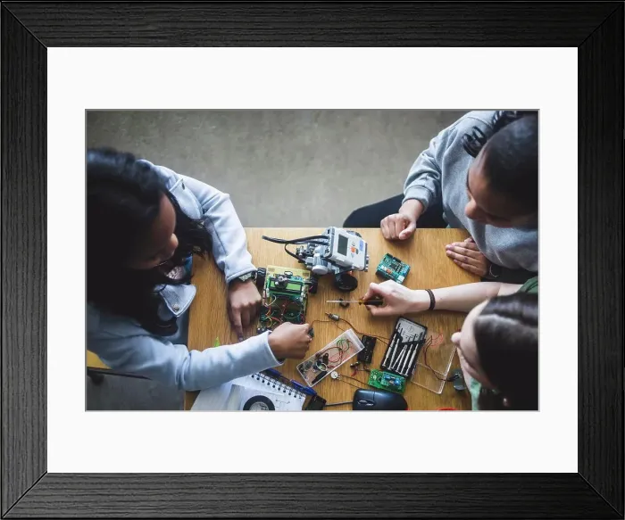 Framed Print : High angle view of multi-ethnic female students preparing science project at desk in high school classroom Framed Print : High angle view of multi-ethnic female students preparing science project at desk in high school classroom