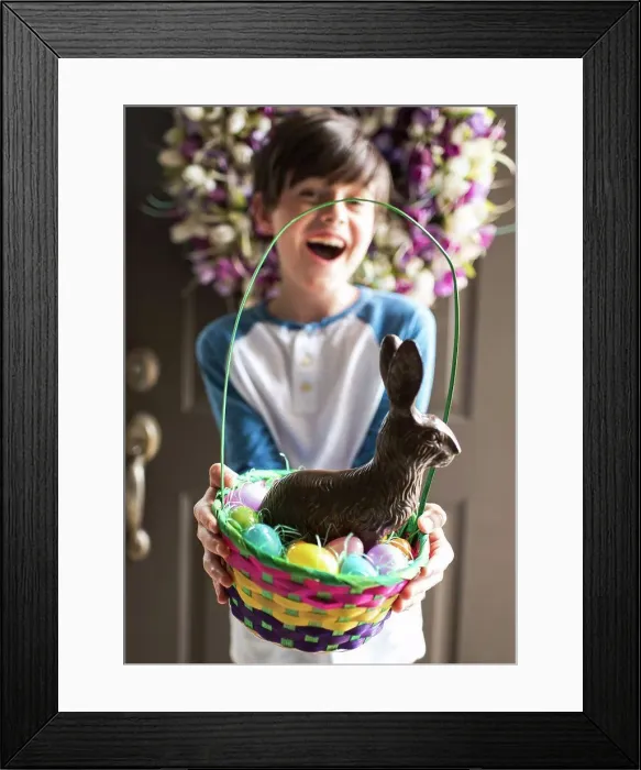 Framed Print : Young happy boy holding Easter basket full of eggs and chocolate bunny Framed Print : Young happy boy holding Easter basket full of eggs and chocolate bunny