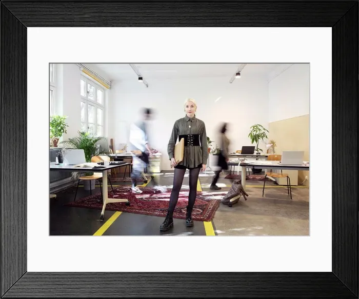 Framed Print : Young woman standing in busy creative co-working space Framed Print : Young woman standing in busy creative co-working space