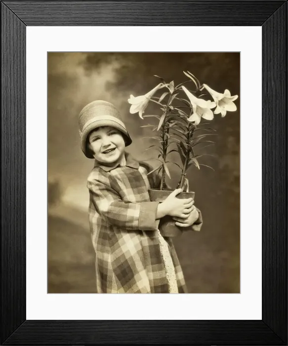 Framed Print : 1920s 1930s SMILING LITTLE GIRL LOOKING AT CAMERA WEARING PLAID COAT CLOCHE HAT HOLDING A POT OF EASTER LILIES Framed Print : 1920s 1930s SMILING LITTLE GIRL LOOKING AT CAMERA WEARING PLAID COAT CLOCHE HAT HOLDING A POT OF EASTER LILIES