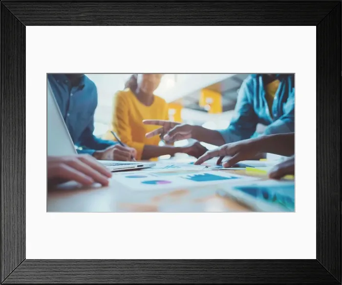 Framed Print : Diverse Team Collaborating Around Laptop Screen with Data Visualization in Modern Office Environment