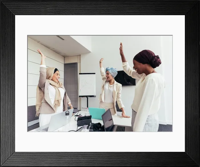 Framed Print : Businesswomen raising arms together