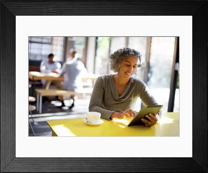 Framed Print : Older woman using digital tablet in cafe Framed Print : Older woman using digital tablet in cafe