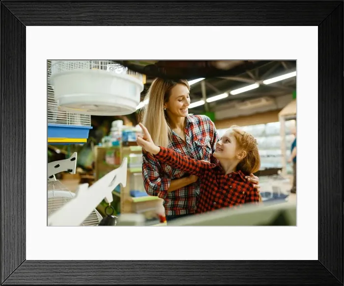 Framed Print : Mother with daughter choosing cage for bird at the showcase in pet store Framed Print : Mother with daughter choosing cage for bird at the showcase in pet store