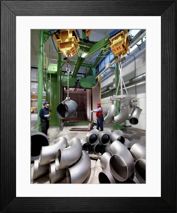 Framed Print : Men working in a steel factory, lifting u-bend tubes on winches Framed Print : Men working in a steel factory, lifting u-bend tubes on winches