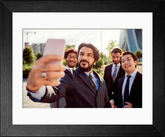 Framed Print : Mixed race group of businessmen hanging out together in town, taking selfie with mobile phone Framed Print : Mixed race group of businessmen hanging out together in town, taking selfie with mobile phone