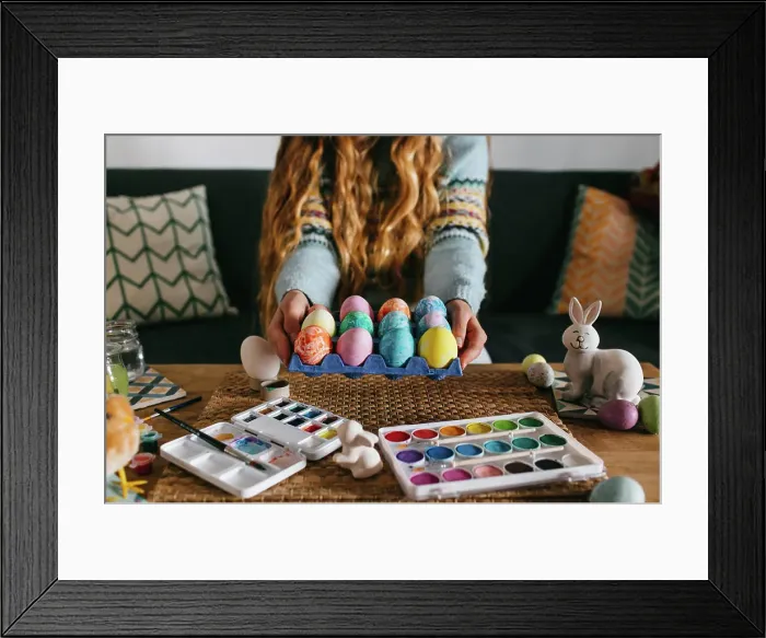 Framed Print : Unrecognizable female in sweater demonstrating carton with set of painted Easter eggs while sitting on sofa Framed Print : Unrecognizable female in sweater demonstrating carton with set of painted Easter eggs while sitting on sofa
