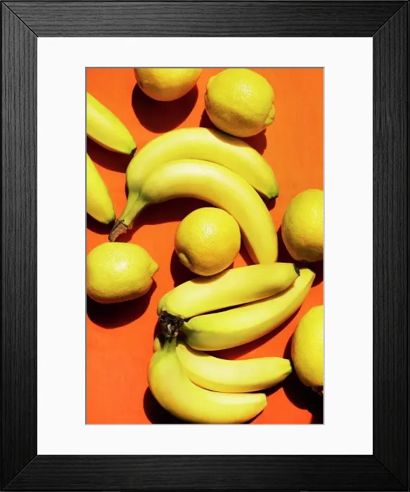 Framed Print : Overhead view of bananas and lemons on orange background Framed Print : Overhead view of bananas and lemons on orange background