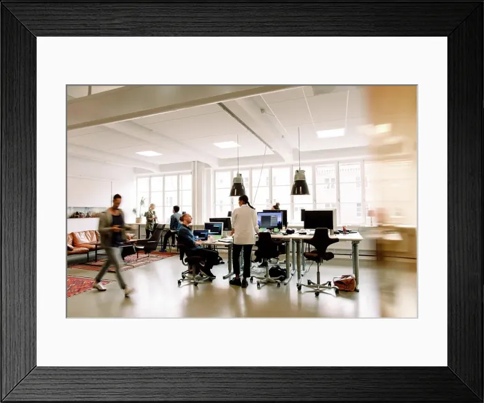 Framed Print : Male and female business colleagues working in creative office space