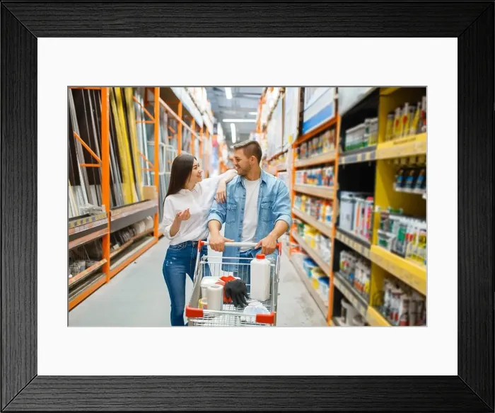 Framed Print : Couple with a cart buying building materials in hardware store. Customers look at the goods in diy shop Framed Print : Couple with a cart buying building materials in hardware store. Customers look at the goods in diy shop
